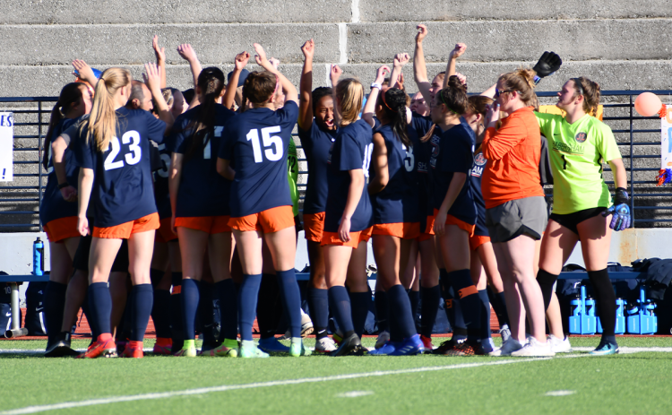 The Lady Raiders raise their fists before breaking the pre-game huddle just before their first-round state playoff game. CODY ROGERS/Staff