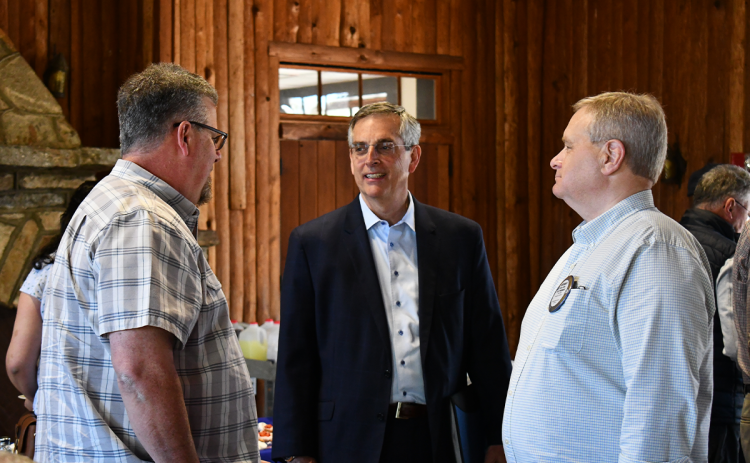 Duane Hartness (left) and Anthony Dalton (right) speak to Sec. Brad Raffensperger (middle) at the Community House on Thursday. BRIAN WELLMEIER/Staff