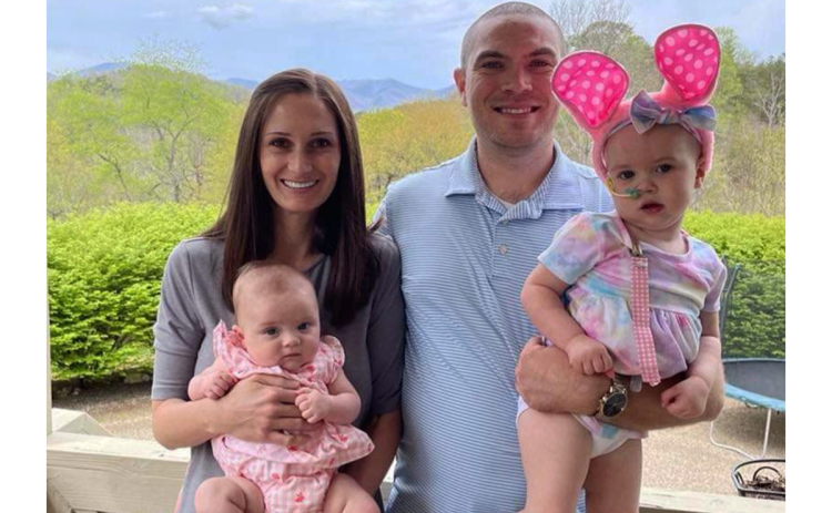 Corey Roberts holds his 2-year-old daughter, Sarah, as his wife Ranae smiles with baby Anna. The Roberts family, who attends Foundations Academy, said they are grateful that Sarah is halfway through her chemotherapy. SUBMITTED