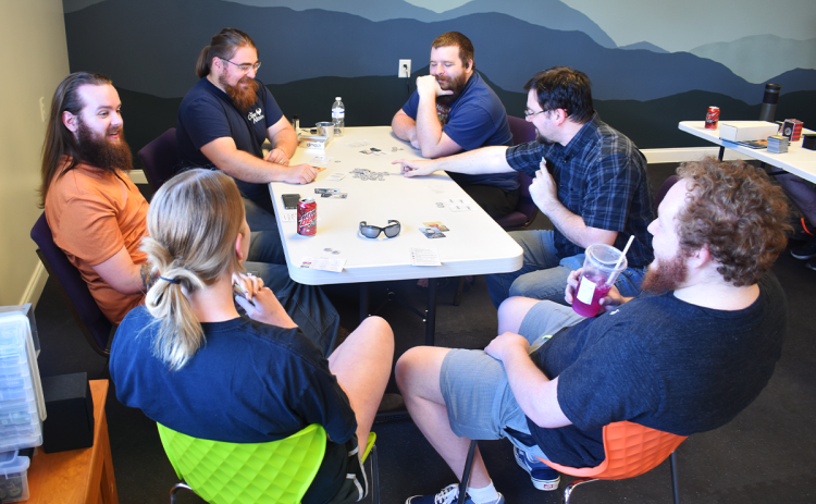 A group of friends enjoys their time playing Coup at The Games Alliance in Clarkesville. AMARIS E. RODRIGUEZ/Staff