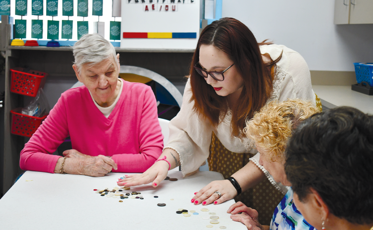 Courtney Underwood assist seniors with crafts at the Senior Center on Monday afternoon. BRIAN WELLMEIER/Staff