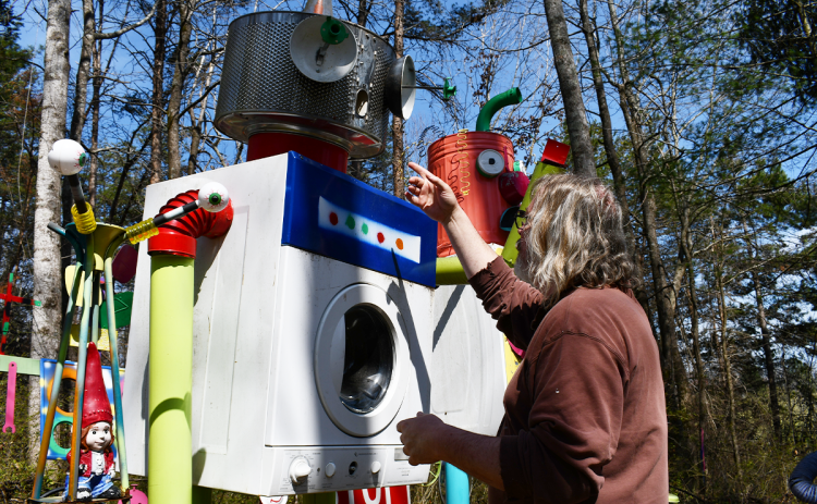Artist Sam Granger gestures at one of his art creations on his Habersham County property. BRIAN WELLMEIER/Staff