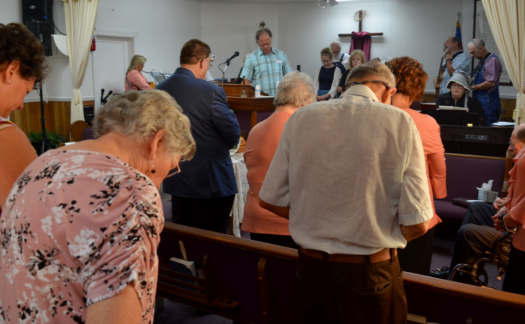 Pastor Joe Frady leads the congregation in prayer Sunday at Old Nacoochee Baptist Church. The church is on the border of Habersham and White counties and has been at its present home since 1851. WAYNE KNUCKLES/CNI News Service