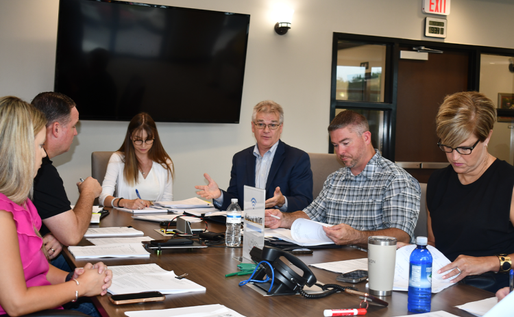 Brittany Taylor, associate attorney with Hunt and Taylor Law Group, Justin Schapansky, Amanda Rostin and Phil Eberly Lead Edge Design, Airport Manager Will Regan and County Manager Alicia Vaughn discuss airport affairs at a Monday meeting. BRIAN WELLMEIER/Staff