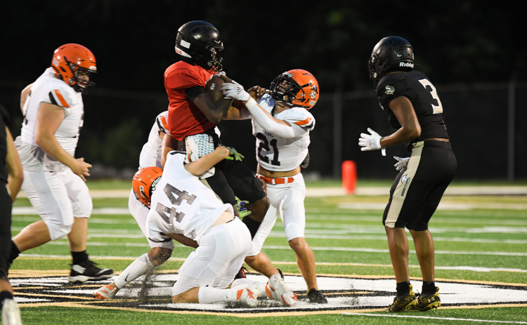 Habersham Central defenders Landyn Savage (21) and Caleb Blackburn (44) sack East Hall quarterback Jamarcus Harrison during the Raiders’ resounding 47-0 win in the preseason jamboree Friday night. TOM ASKEW/Special