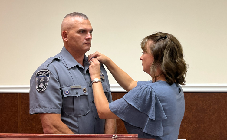 April Jones pins her husband Chris Jones with the new rank of Baldwin Police Chief. BRIAN WELLMEIER/Staff