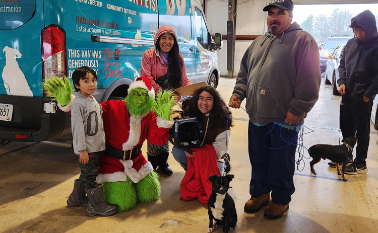From left, son Alex, the Grinch played by Madi Nix, mother Rafela Ramos, daughter Yanet, husband Jose Rodriguez, son Esteban enjoy the free clinic hosted by Habersham County Animal Shelter and partners Dec. 10. SUBMITTED