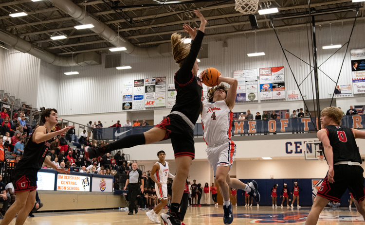 Habersham Central’s point guard Brannon Gaines drives hard to the basket against a  Gainesville defender to keep the Raiders close in Friday night’s game. ZACH TAYLOR/Staff