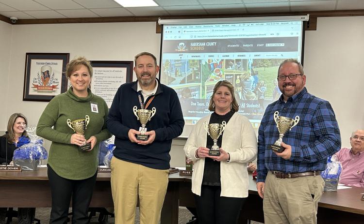 Principals (from left) Lana Jones, Jonathan Stribling, Georgia Pitts and Ernie Garrett receive their attendance trophies at Monday night’s Board of Education meeting. EMMA MARTI/Staff