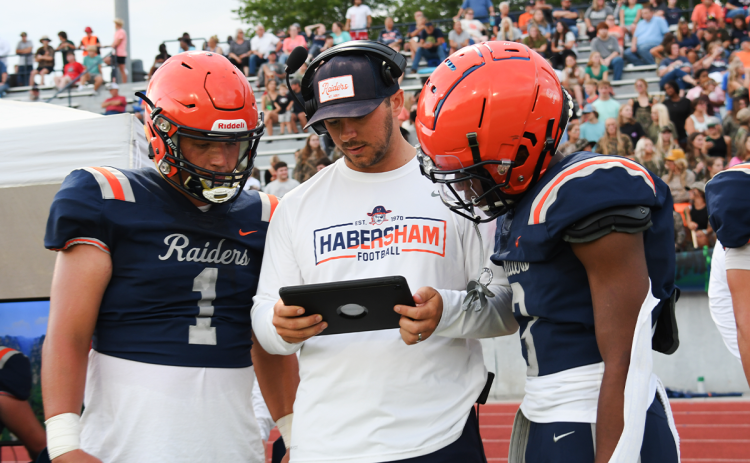 Hayes Gunn (left) and Micah White consult with assistant coach Jordan Banks during the Raiders’ preseason win over East Hall. Habersham Central hosts Stephens County at 7:30 p.m. Friday. TOM ASKEW/Special