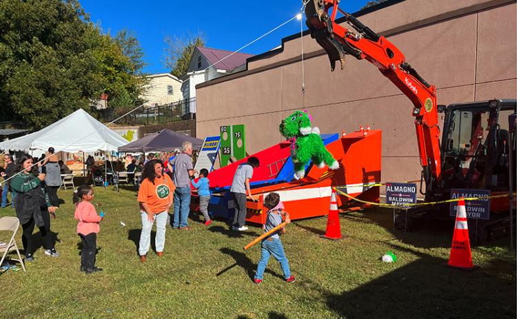 Children take whacks at a pinata at the Baldwin Fall Festival on Saturday. The fun party favor was hanging from a city excavator which was flanked by Stephanie Almagno for Mayor signs. CITY OF BALDWIN/Submitted
