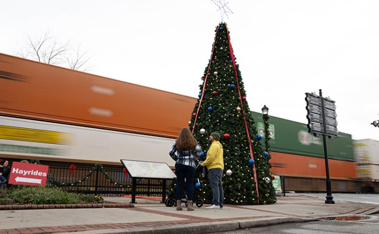 In typical Cornelia fashion, a train rolls by as Chris and Alicia Baratki stand next to the Christmas tree. ZACH TAYLOR/Special