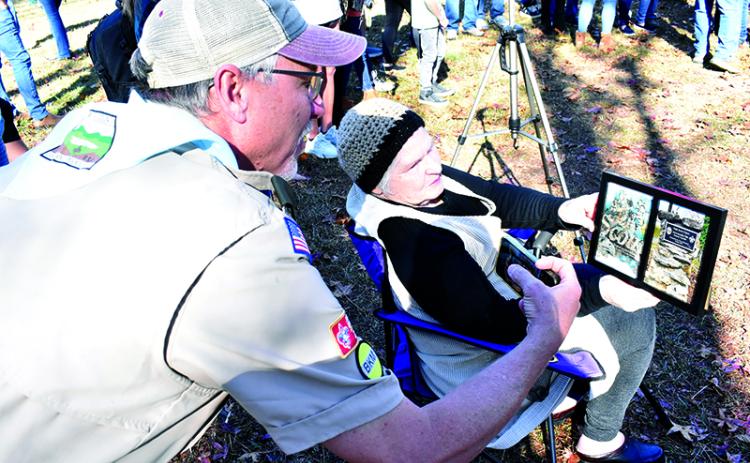 Scout Troop 5 Assistant Scoutmaster Alan Baker looks at a framed handbook page given to Alice Roseman that was left in the ground by her son Travis when he completed his Eagle Scout project in 1985. MATTHEW OSBORNE/Staff