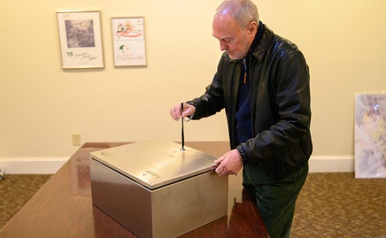 Councilmember Brad Coppedge uses a butter knife to open the time capsule. ZACH TAYLOR/Special