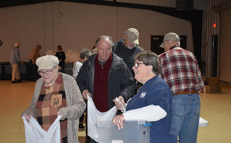 From left, Stella Ward, Bob Cook, Sam Watkins and Renè Grant work to fill the bags to be delivered to the schools later in the day. At far right is Richard Monroe. MATTHEW OSBORNE/Staff