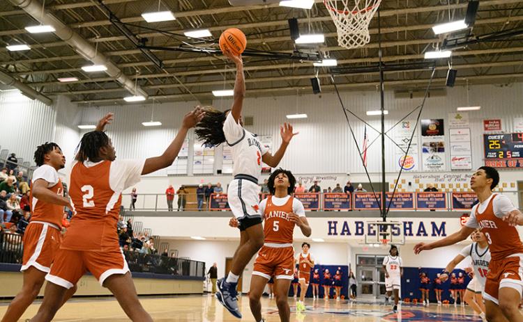 Habersham Central’s Enzo Combs floats to the rim for two points for the Raiders against Lanier on Tuesday night over the Longhorns’ Amari Morgan (5). ZACH TAYLOR/Special