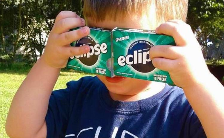 G.A. Moon, in his younger days in 2017, finds a unique way to shield his eyes from the eclipse. FILE