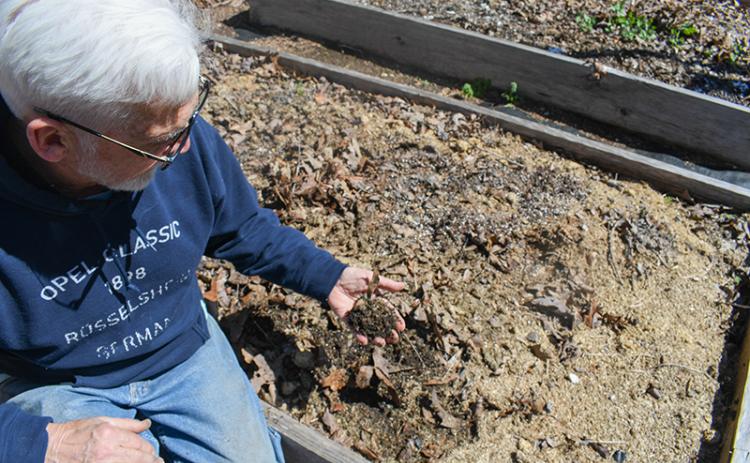 John Mather holds his carefully curated soil mixture full of wood chips, horse manure, compost, ash and other organic materials. JULIANNE AKERS/Staff