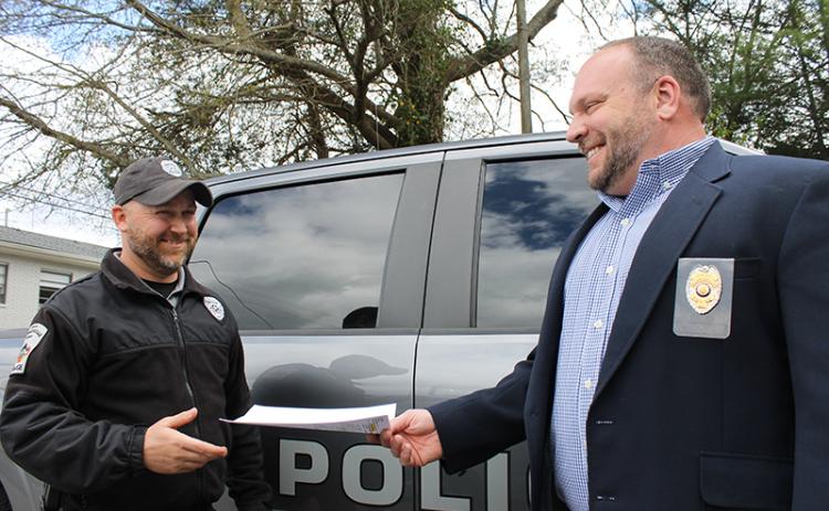Clarkesville Police Chief Brad Barrett (right) gives a commendation to Sgt. Ryan Ledford (left) for going above and beyond to save a person trapped in a burning vehicle. BRIAN WELLMEIER/Special