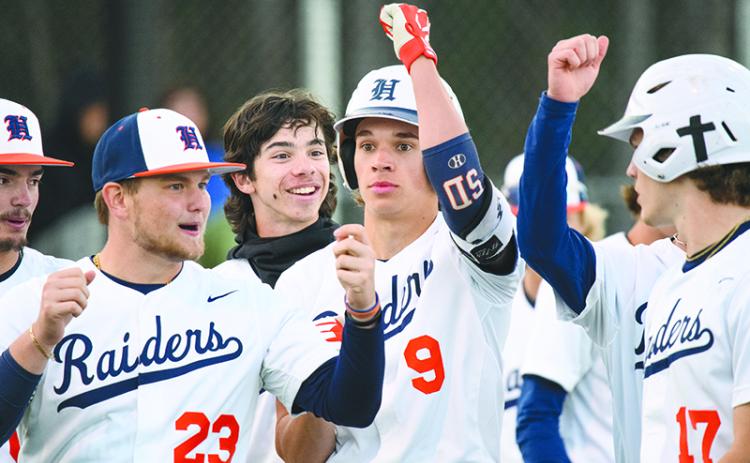 The Raiders celebrate with  Konnor Burrell after he hit a  two-run home run in the bottom of the 5th  inning against Apalachee last week. ZACH TAYLOR/ Special