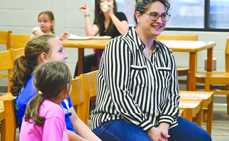 Author and illustrator Shanda McCloskey, right, chats with sisters Adalee and Ansley Guess about her books at Wilbanks Middle School on April 18. JULIANNE AKERS/Staff