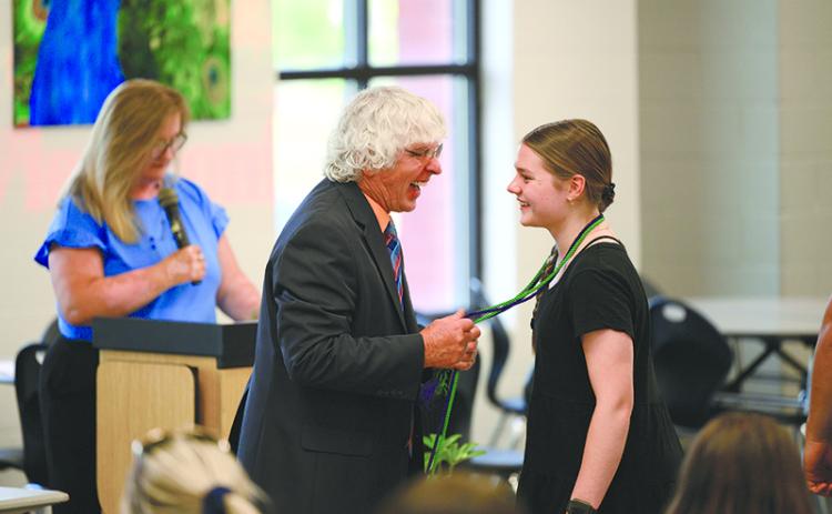 Coach Morris Brooks smiles as he puts the Work-Based Learning cord on  Habersham Central senior Kaitlyn  Gibson at Thursday’s annual banquet. ZACH TAYLOR/Special