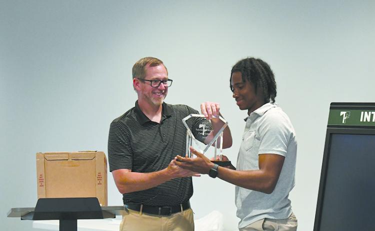 TFS coach Justin Pollock presents Indians’ catcher Caden Walker with the team’s MVP award at the banquet Tuesday. LANG STOREY/Staff