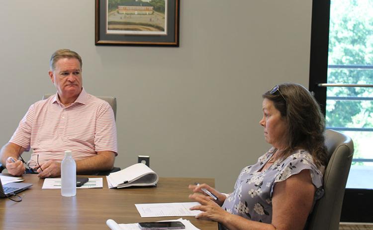 Pilot Michelle Curcio (right) talks to the Airport Commission on Tuesday as County CFO Tim Sims listens.
