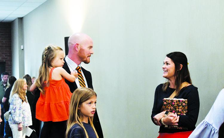 Adam Bagwell holds his daughter Emi while chatting with Clarkesville  Elementary Assistant Principal Kellie Cash. JULIANNE AKERS/Staff