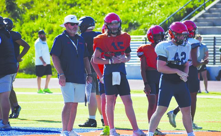 Coach Benji Harrison and quarterback DJ Pass look on as the second team lines up during padded camp. LANG STOREY/Staff