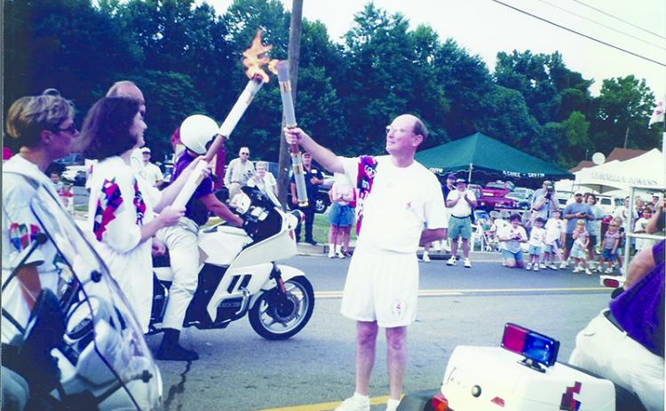 Dr. Martha Cantrell passes the Olympic flame to Community Bank & Trust President Charlie Miller in 1996. Below, Cantrell got to keep her torch to mark the historic moment. SUBMITTED