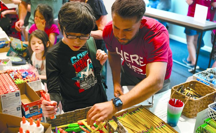 Niko Andrade (right) helps Daniel Arriaga pick the best color highlighters for his upcoming school year at last year’s Back to School Bash in Baldwin. ZACH TAYLOR/Special