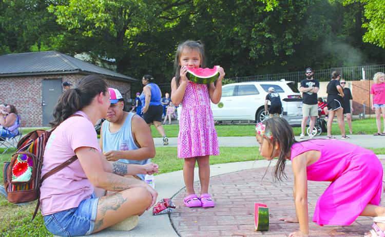 Samantha and Sergio Andres watch their kids Linda and Kylah devour watermelon at Baldwin’s Pit Nic Saturday. BRIAN WELLMEIER/Special