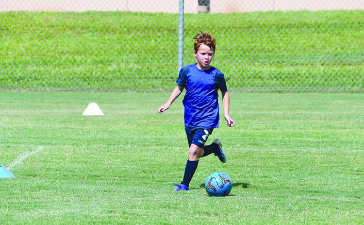Finley Franklin pushes the ball upfield during a scrimmage game at Raider Soccer camp.