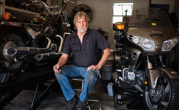 Kenneth Pardue sits beside motorcycles in his shop, Rooster’s Cycles. ZACH TAYLOR/Staff