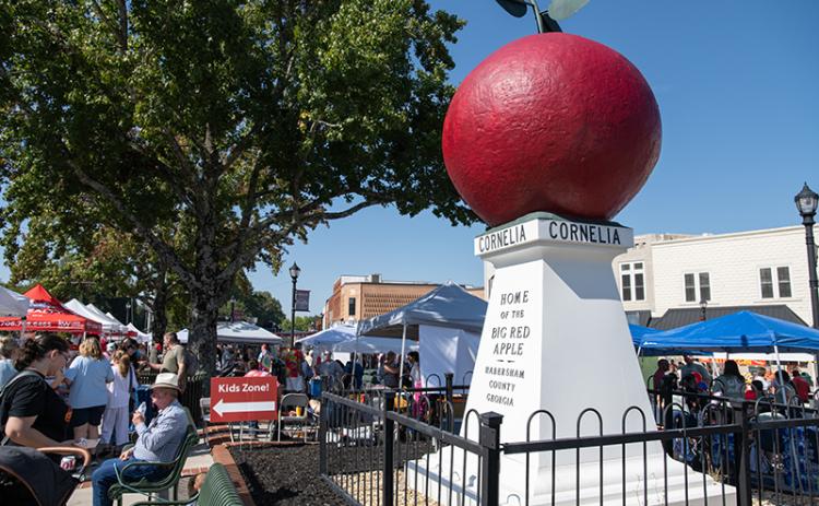 The Big Red Apple sits in the sun in downtown Cornelia on Saturday, surrounded by people. ZACH TAYLOR/Staff