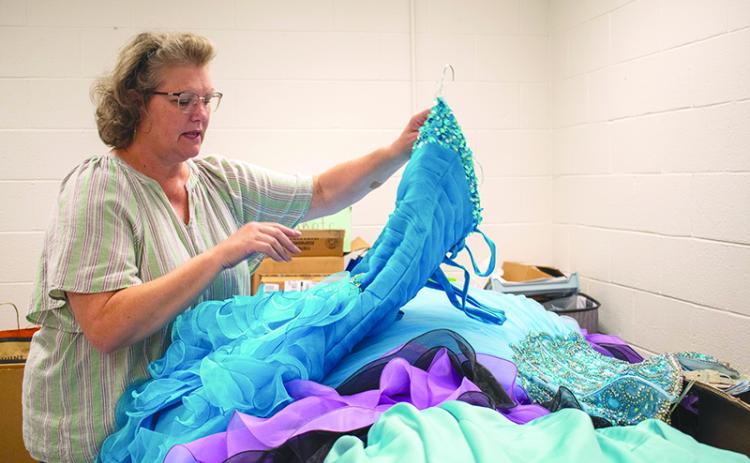 Habersham County Family Connection Executive Director Donna Barrett sorts through donated dresses. JULIANNE AKERS/Staff