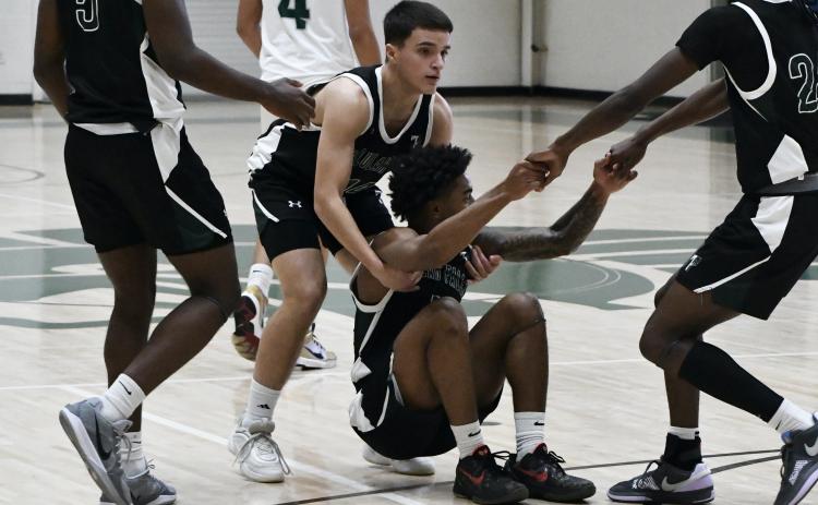 Neyo Bain is helped to his feet by teammates after missing a buzzer beater at the end of the 1st half Saturday. LANG STOREY/Staff
