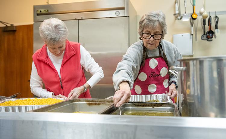 Claudia Jessup and Tina Evans work to get the most out of the corn and green bean batches. ZACH TAYLOR/Staff