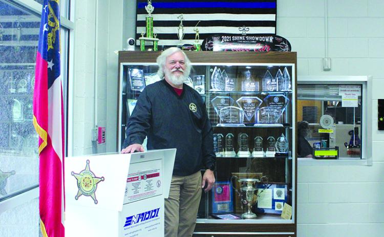 Sheriff Joey Terrell stands in front of the trophies detailing the police department’s accolades. HANNAH CAUDELL/Staff