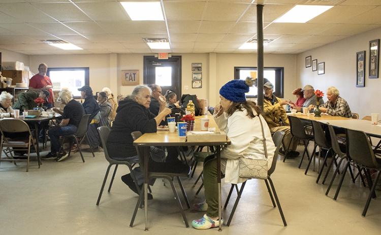 From left, Jennie Tomlin sits and chats across the table from Diane Higgins, who enjoys a warm cup of chili on a cold December day. HANNAH CAUDELL/Staff