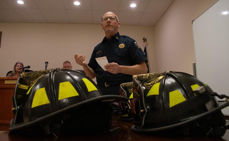 Baldwin Fire Chief Joe Roy stands before the audience at the Baldwin City Council meeting on Monday night to talk about Baldwin’s first department graduating class. New firefighter helmets sat on the table before him. Helmets are traditionally given to new firefighters upon graduation. HANNAH CAUDELL/Staff