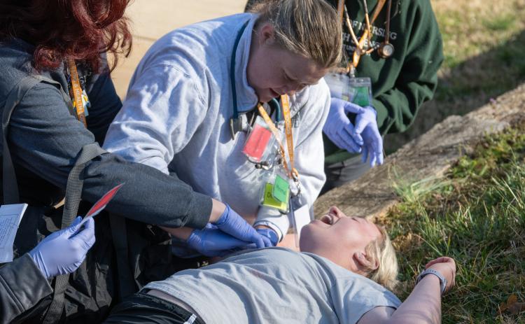 Piedmont nursing student Gracie Martin puts pressure on a gunshot wound during the disaster drill. Nursing students got a firsthand look at what a chaotic scene in the real world could look like. ZACH TAYLOR/Staff