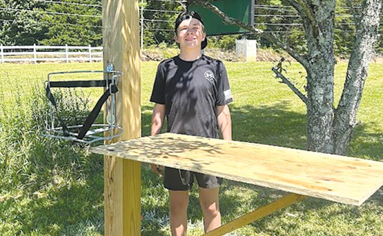 Thatcher Tatum shows one of the water stands he led a team of Scouts and leaders to build last summer at Tallulah Falls School. SUBMITTED