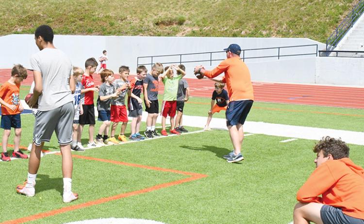 Coach Tate Gailey instructs campers in a wide receiver drill in 2023.
