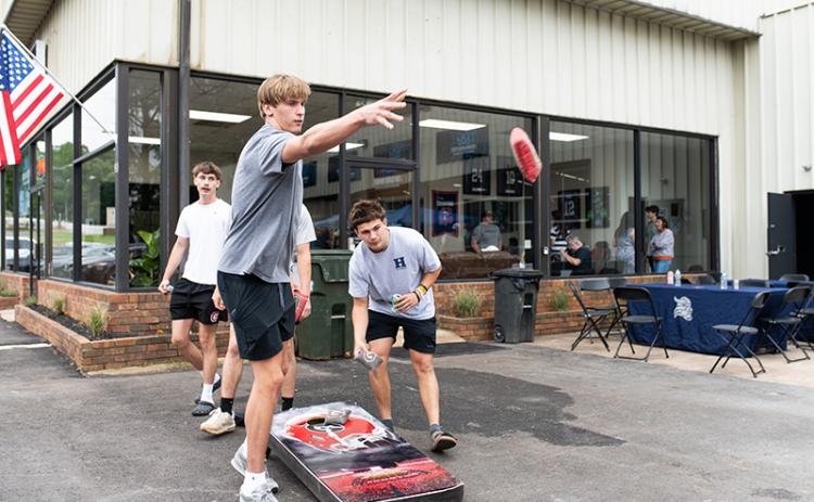 Habersham Central basketball stars and All-Regions pick Judge and Paris Wilbanks play cornhole at Crown Athletics’ grand opening ceremony on Saturday. ZACH TAYLOR/Staff