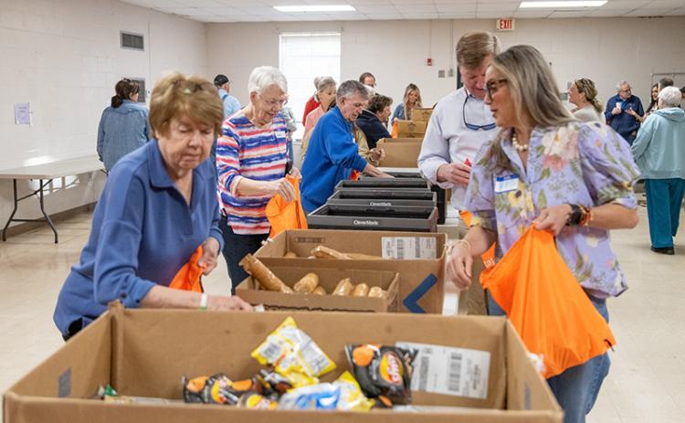 The folks from Food 4 Kids pack up some meals for kids in need in the Habersham County community. FILE