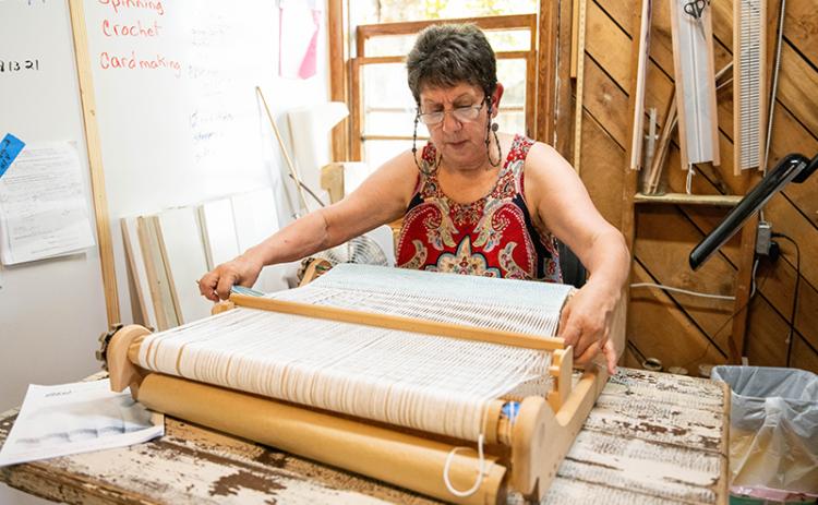 Gene Pease weaves on a heddle loom in the new AppalachianGap studio near the Art-Ful Barn’s new location off Ga. 17 in Clarkesville. ZACH TAYLOR/Staff
