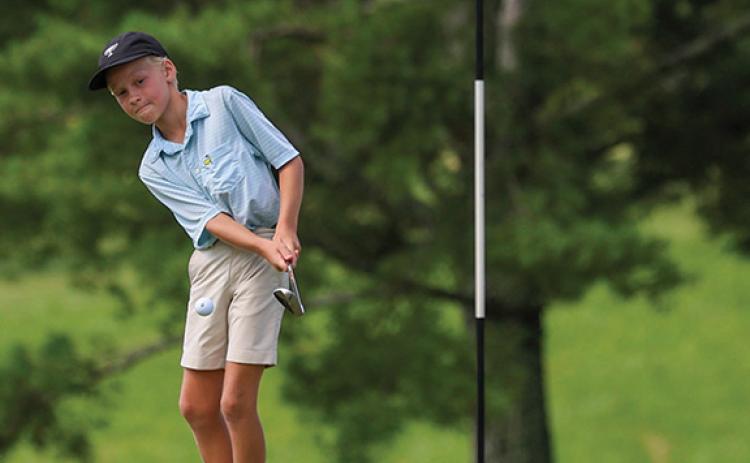 Camper Fletcher Lunsford hits the ball toward the hole during session four of the golf camp at Apple Mountain Golf Club & Resort on Wednesday, July 2. (Landen Todd/Staff)