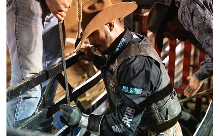 Austin Beaty of Glade Hill, Va., gets his hand tacked up with rosin before locking his hands into a rope on a bull during last year’s rodeo. (Zach Taylor/Staff)